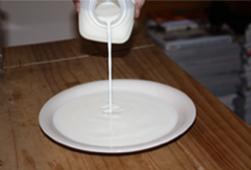 Pour enough milk into the jar lid or bowl.